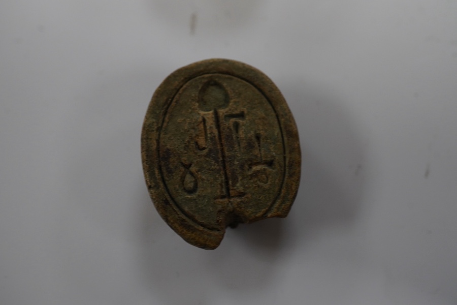 Three ancient Egyptian carved stone ushabti, tallest 15cm, with carved hieroglyphs to the body, together with a seated figure, possibly of Isis, a scarab and a yellow metal brooch with inset stone carved with hieroglyphs